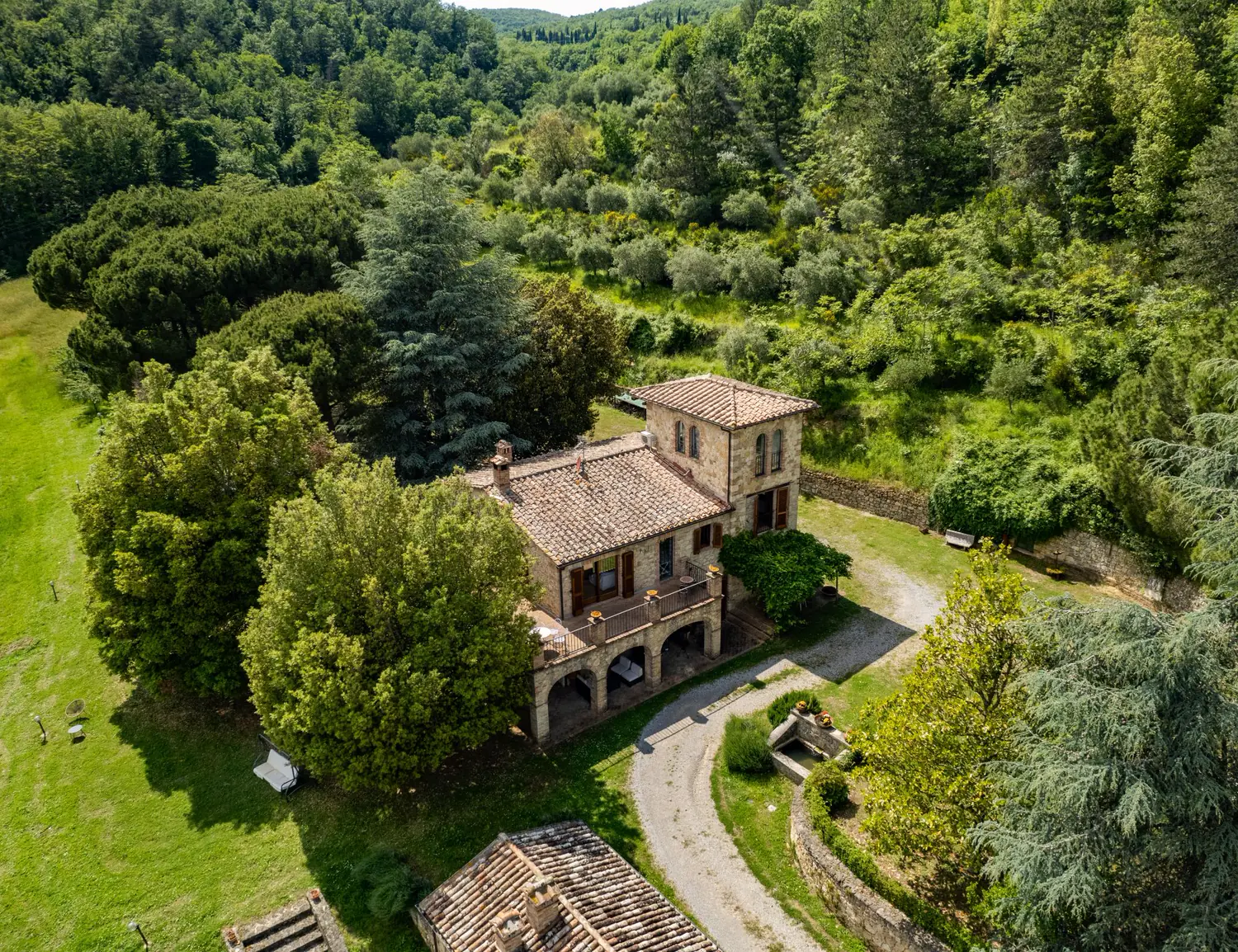 Un casale di pietra fra i boschi e gli ulivi, dal drone
